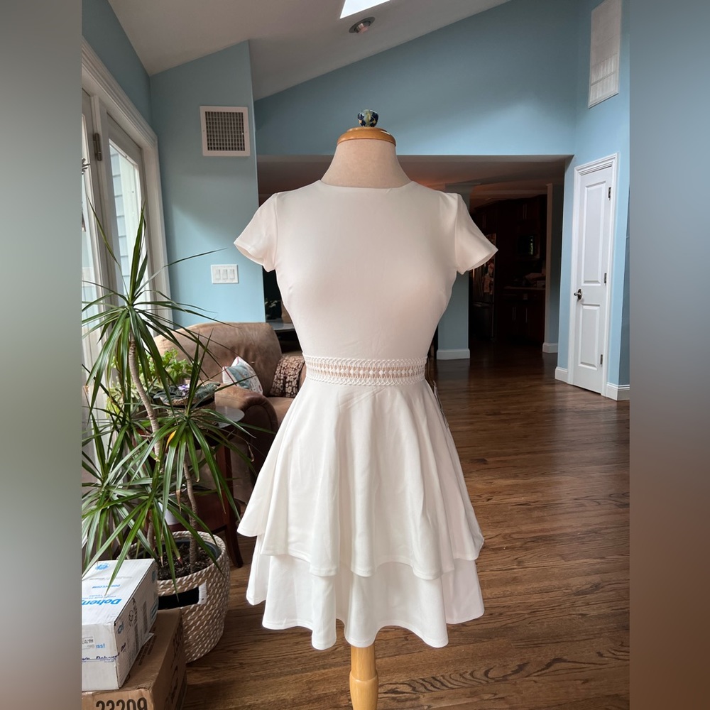 White, flowy, short sleeve dress. Falls to a few inches above the knee.